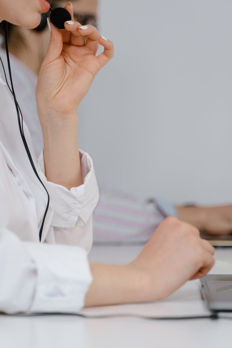 A focused call center professional using a headset at work in an office setting.
